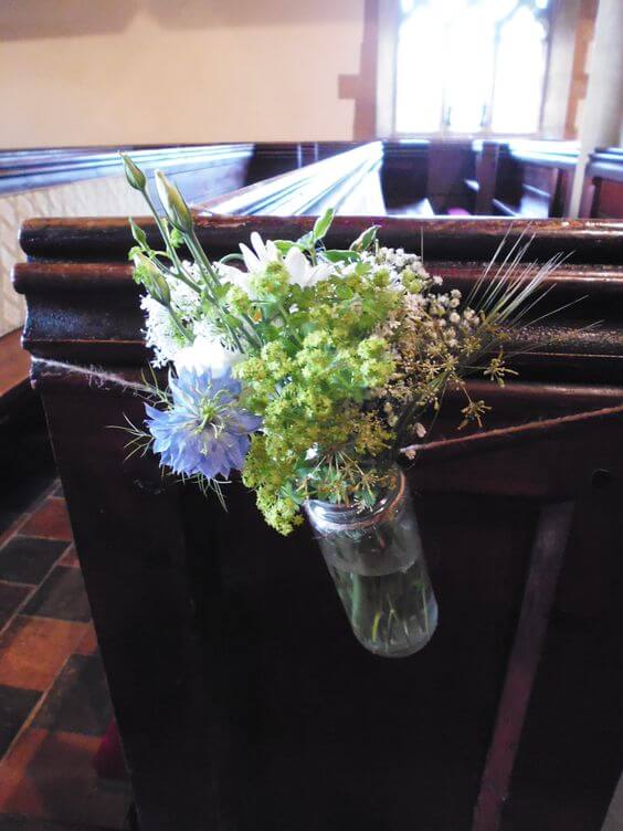 Jam jar pew end rustic flower arrangement